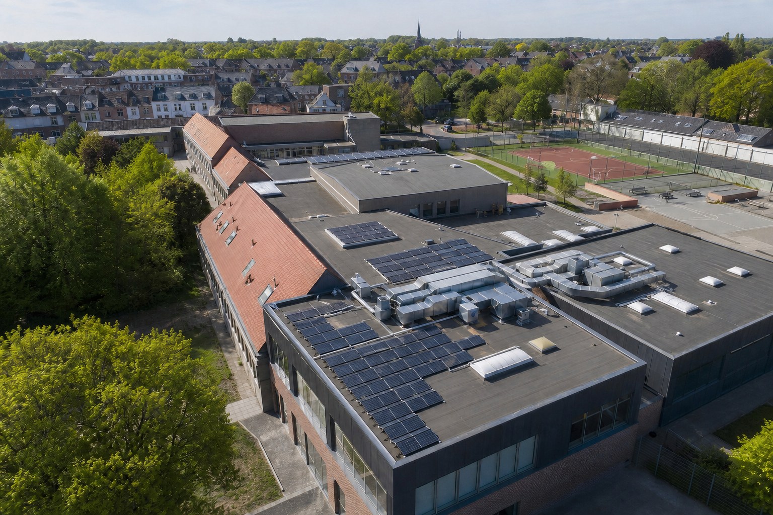Publiek schoolgebouw met verschillende dakvormen en zonnepanelen